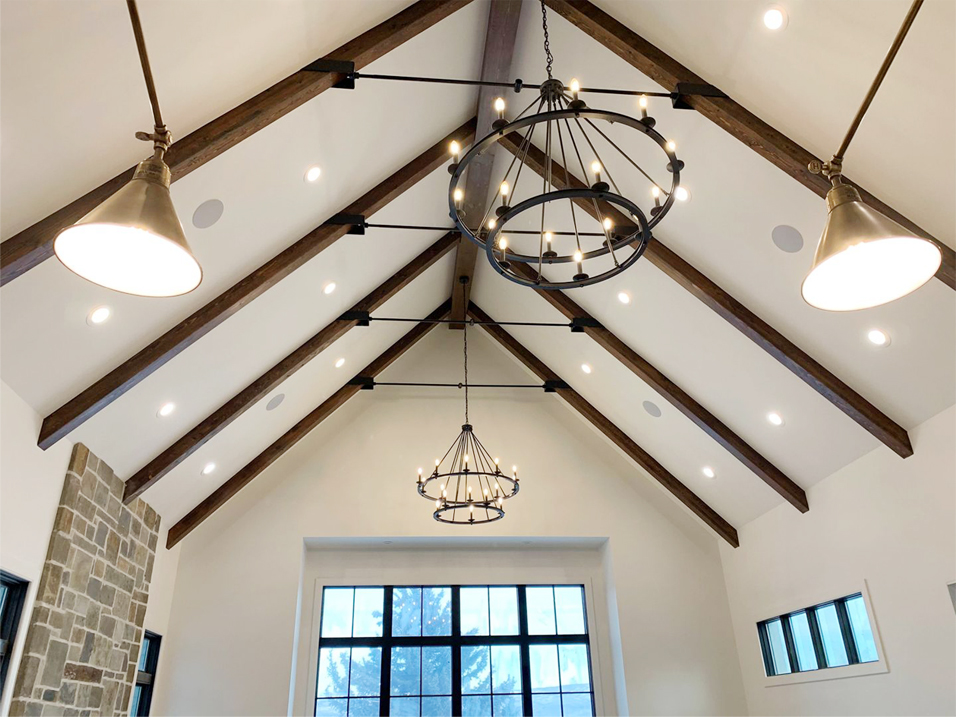 A room with two large windows and a chandelier.