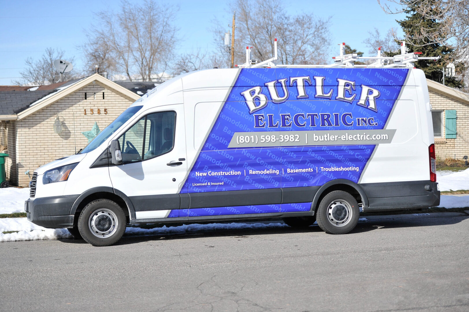 A white van with blue and black lettering on the side.