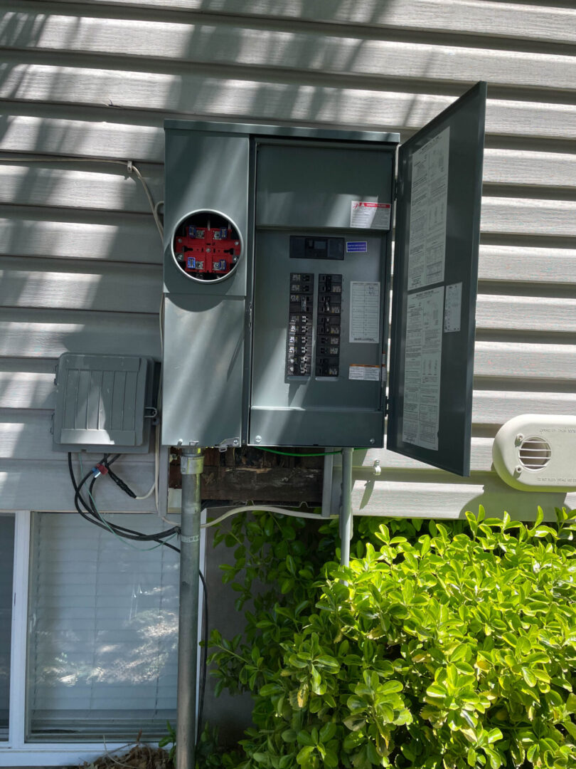 An upgraded grey electric circuit panel box on the outside if a house in Sandy UT